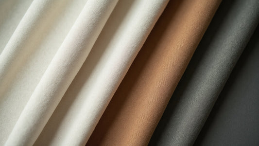 Three warm-weather shirt fabric swatches in linen, cotton and oxford weaves side by side in daylight.