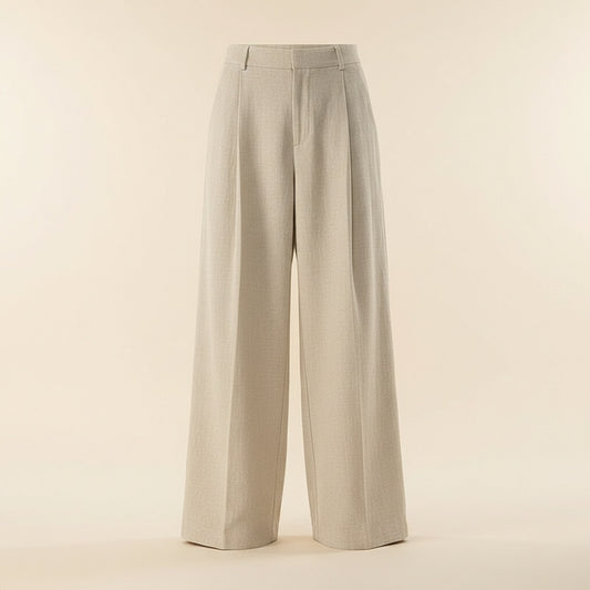 Ecru pleated trousers styled with a soft grey ribbed tank, shown full-length against a warm neutral studio backdrop.