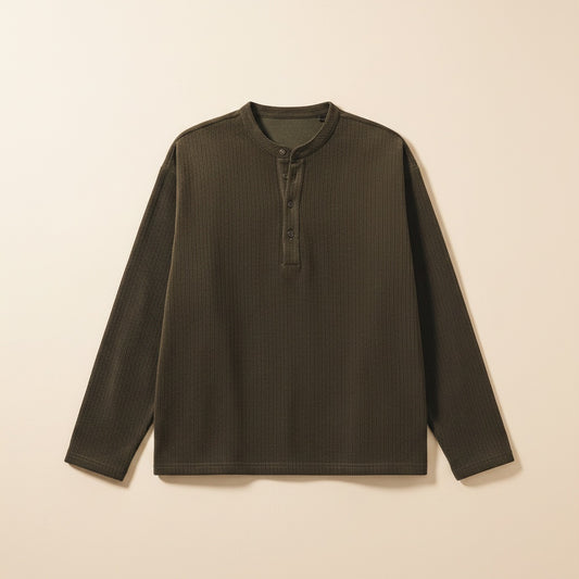 Ribbed henley top in deep forest green with band collar and button placket, styled with tonal trousers in warm studio light.