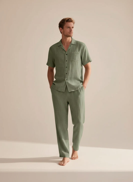 Sage green camp-collar shirt and straight-leg trouser set in soft linen, styled for quiet coastal ease on warm neutral studio backdrop.