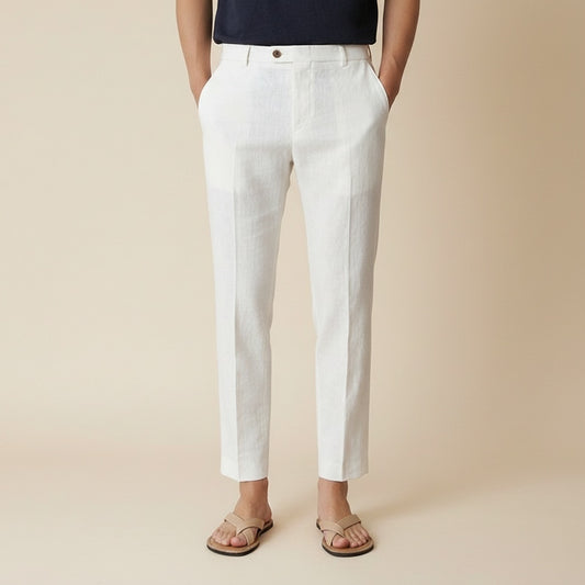 Ivory cropped tapered trousers with pressed centre crease, styled with a stone ribbed tank top in warm studio light.