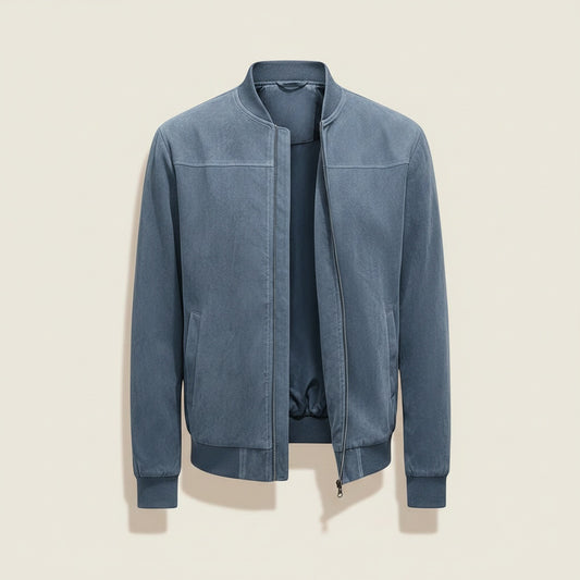 Slate blue jacket styled with heather beige tapered trousers against a warm off-white studio backdrop.
