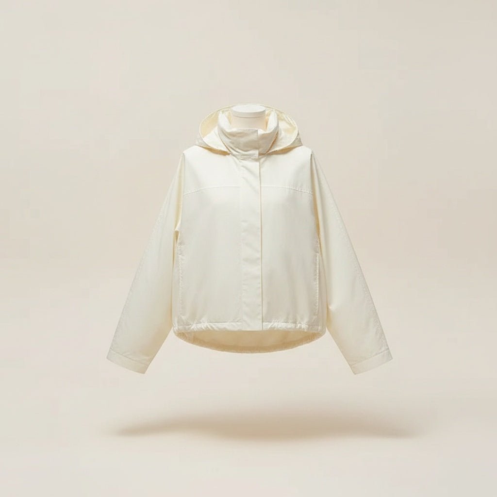 Cropped ivory jacket with soft drawstring detail styled with warm stone tapered trousers in quiet-luxury studio setting.