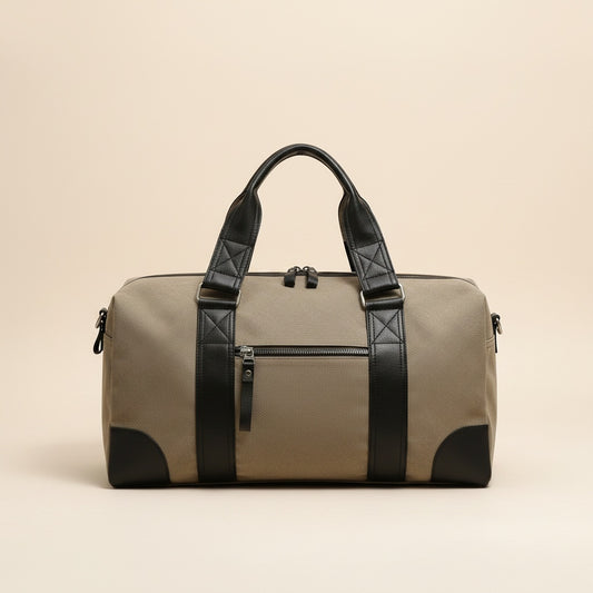 Khaki-olive coated canvas weekender holdall with black leather trim, twin handles, and front zip pocket on warm neutral studio backdrop.
