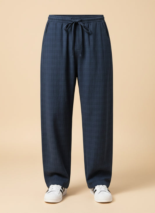 Navy linen-tencel drawstring trouser with tonal check weave, styled in a warm plaster-toned studio setting.