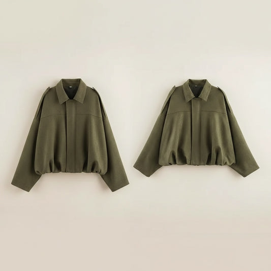 Olive green cropped top styled with high-waisted taupe trousers in a warm neutral studio setting.