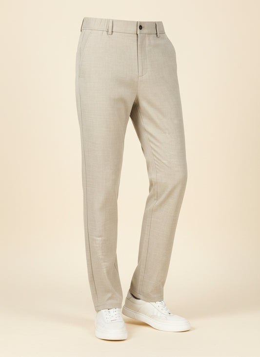 Ivory straight-leg trousers styled with a ribbed tonal tank, quiet-luxury editorial studio portrait in warm neutral light.