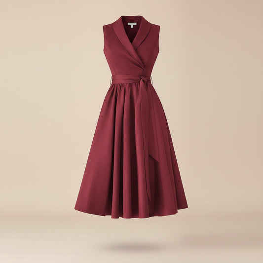 Burgundy sleeveless midi wrap dress with shawl lapel, tie belt at waist, and softly pleated A-line skirt in matte suiting.