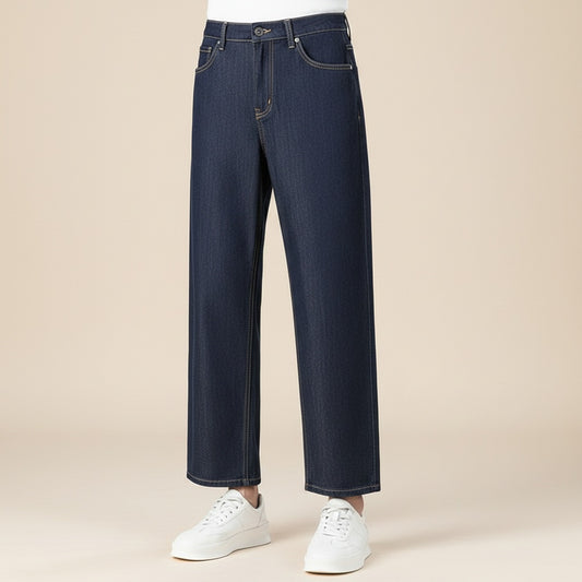 Dark indigo wide-leg cropped jean in fluid lyocell blend, styled with a soft ribbed tank on a warm off-white studio backdrop.