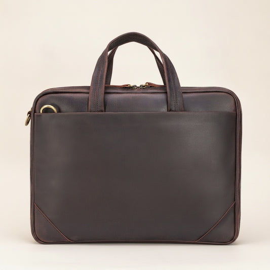 Structured espresso crazy horse leather briefcase with twin rolled handles and reinforced corners on a warm travertine ledge.