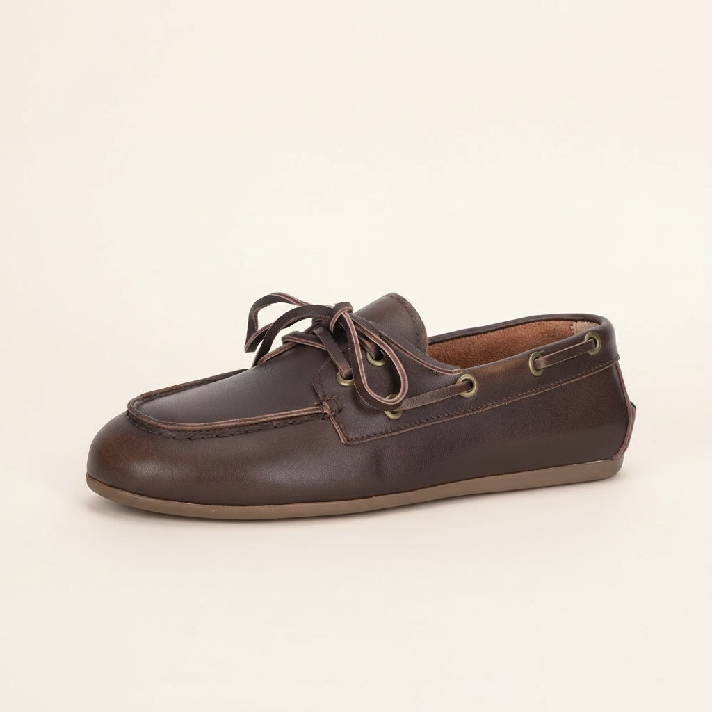 Dark brown leather boat shoe moccasin with hand-stitched moc-toe, rawhide laces, brass eyelets and low gum sole.