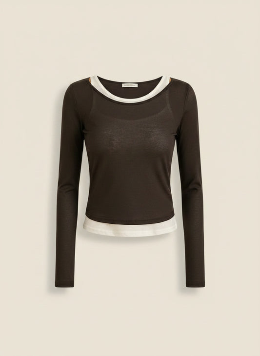 Espresso brown long-sleeve layered tee with cream inner tank, styled with taupe trousers in a warm quiet-luxury studio setting.