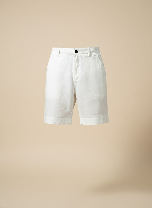 Tailored white pure linen shorts with single-button closure, slanted pockets and turned hem, styled with a ribbed tank for quiet-luxury summer ease.