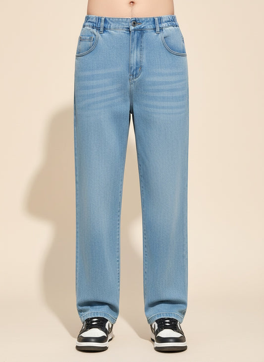 Light-wash relaxed straight-leg lyocell jeans styled with a soft ecru tank top in a warm minimalist studio setting.