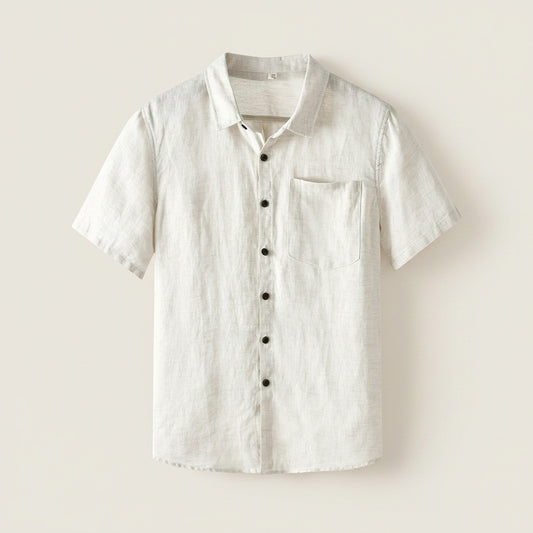 Ivory linen short-sleeve camp shirt with chest pocket and tonal horn-look buttons, styled with sand trousers in warm light.