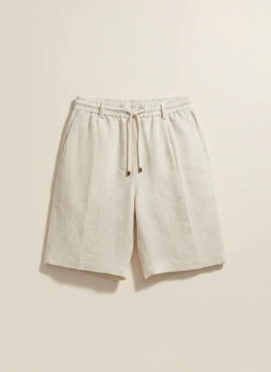 Woman in ribbed stone tank top and tailored taupe tailored shorts, styled in warm minimalist studio light.