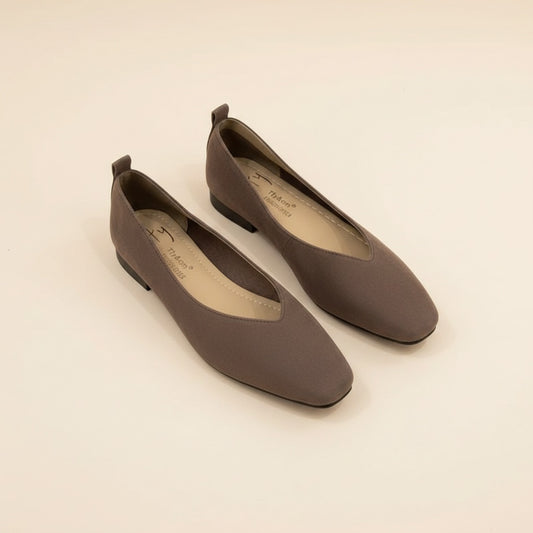 Havana taupe suede square-toe ballet flats with low heel and slip-on silhouette on a warm off-white studio backdrop.