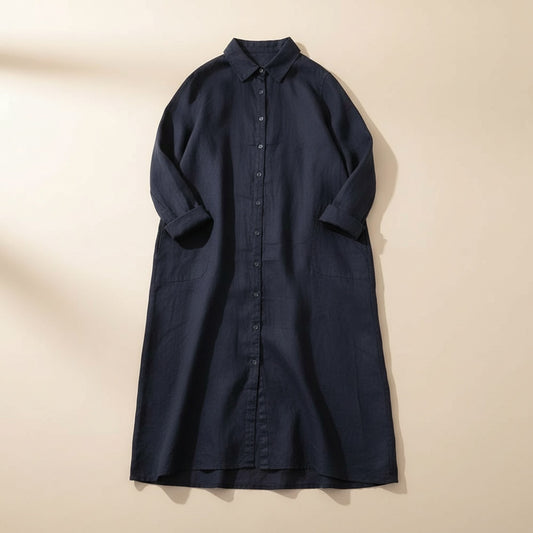 Ink navy relaxed shirt dress with collar, button placket and patch pockets, styled in soft warm studio light.