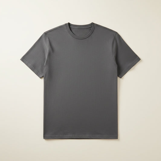 Charcoal grey Supima cotton crew-neck t-shirt with ribbed neckline and relaxed fit, styled on a warm neutral studio backdrop.